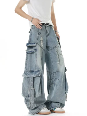 Front view of oversized light blue washed cargo jeans with belted waist, ripped details, wide leg silhouette, and adjustable utility pockets