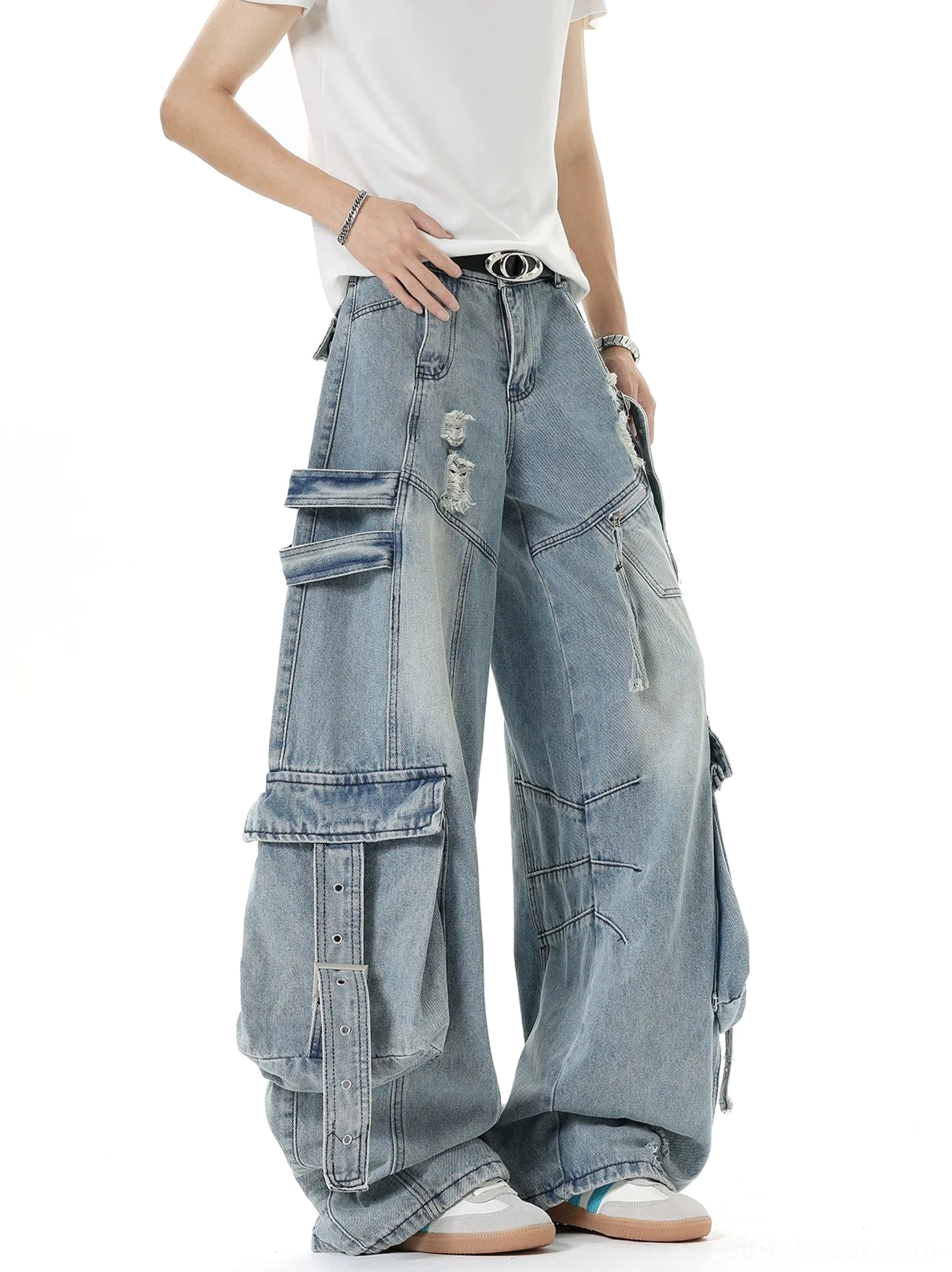 Front view of oversized light blue washed cargo jeans with belted waist, ripped details, wide leg silhouette, and adjustable utility pockets
