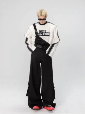 White oversized varsity graphic long sleeve tee with black stripe sleeves styled with black wide-leg pants front full-body view
