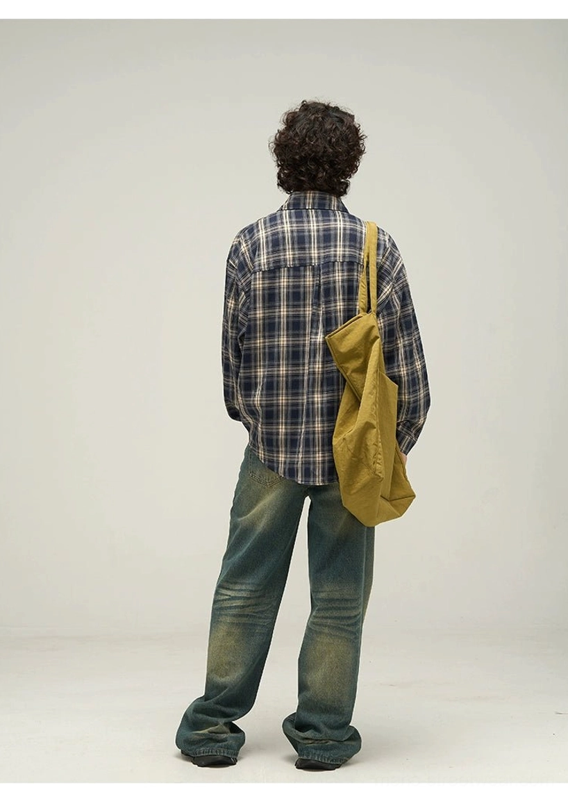 Back view of oversized navy tartan button-up shirt showing back yoke detail curved hem and relaxed streetwear fit