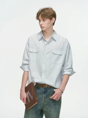 Light blue oversized utility button-down shirt styled with vintage denim jeans, rolled sleeves, dual flap chest pockets, and a relaxed Korean streetwear fit