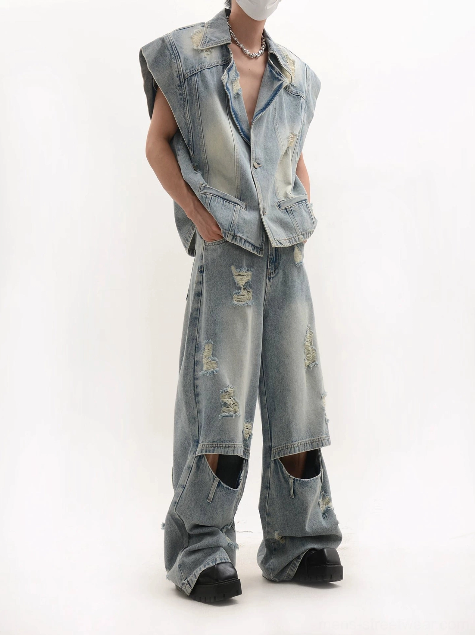 Side front view of a slouchy oversized denim vest with pointed collar and matching distressed blue jeans