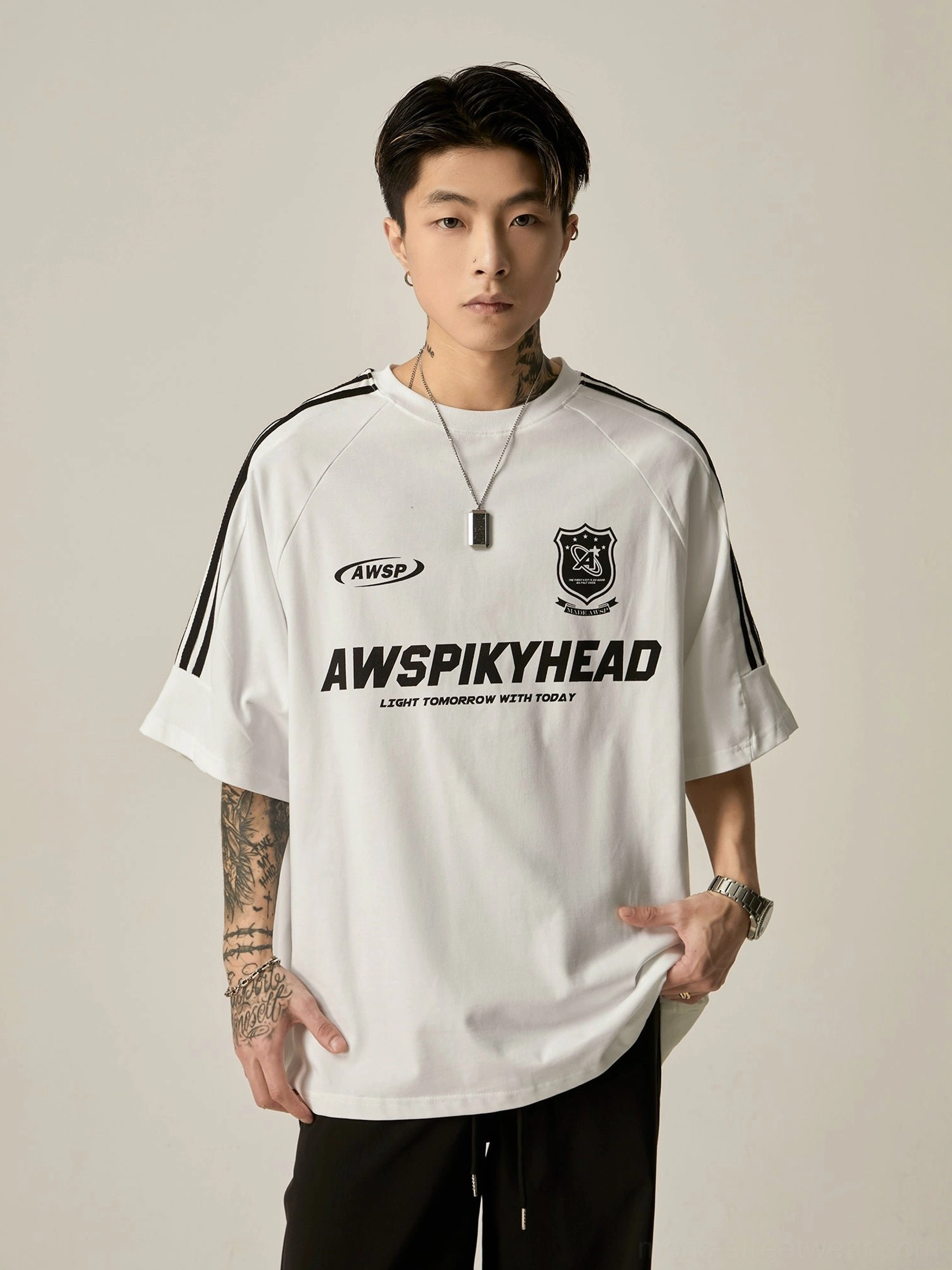 Oversized white athletic raglan graphic tee front portrait view with black sleeve stripe accents and front printed brand graphics
