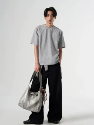 Heather gray oversized raglan sleeve T-shirt shown in a full-body front view with relaxed Korean streetwear styling and a silver tote bag