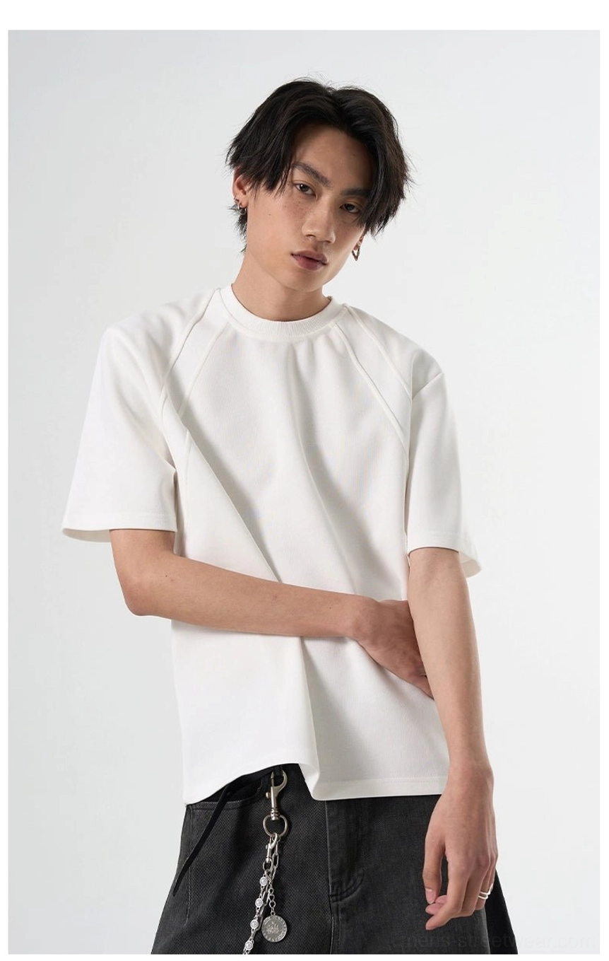 White oversized raglan short-sleeve T-shirt with smooth fabric styled with dark gray wide-leg pants and chain details