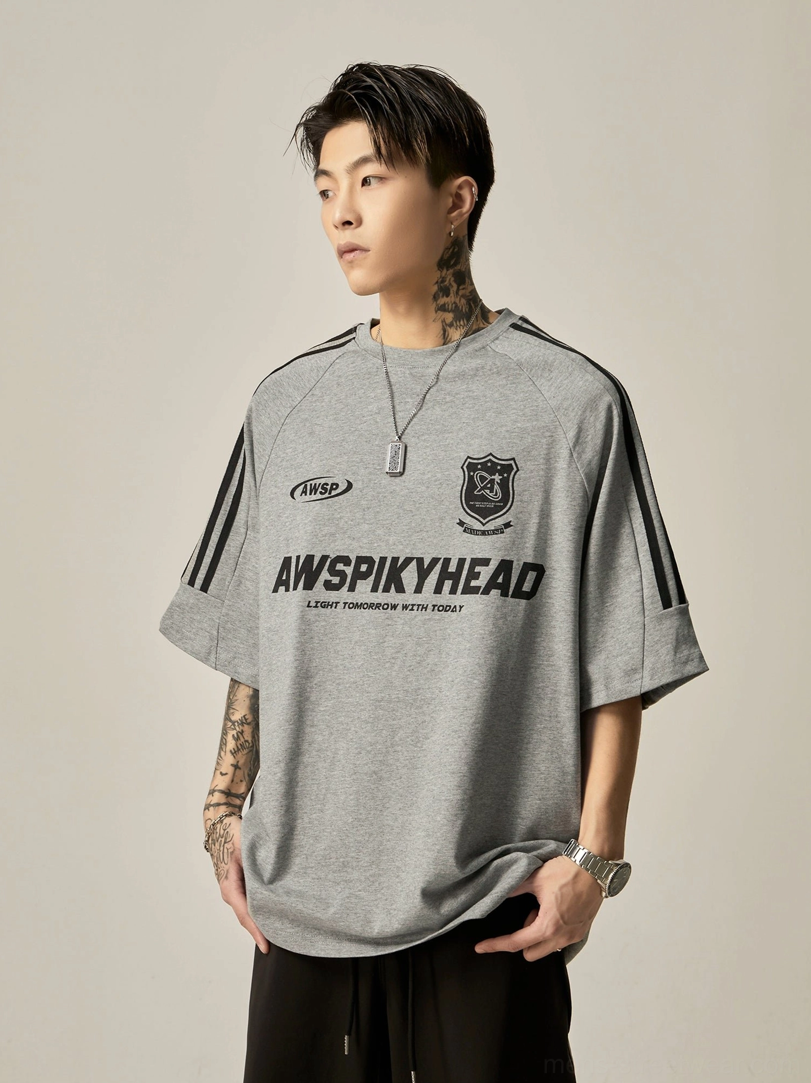 Oversized grey football-themed raglan graphic tee straight front portrait streetwear look with AWSPIKYHEAD branding and shield logos on chest