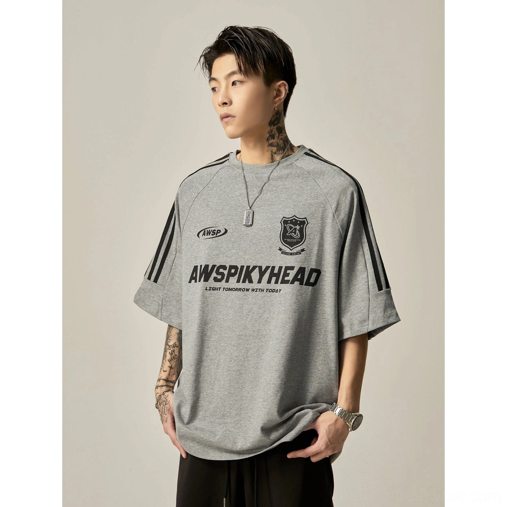 Oversized heather grey raglan athletic graphic tee full body front view with complete front brand graphic set and black stripe sleeve details