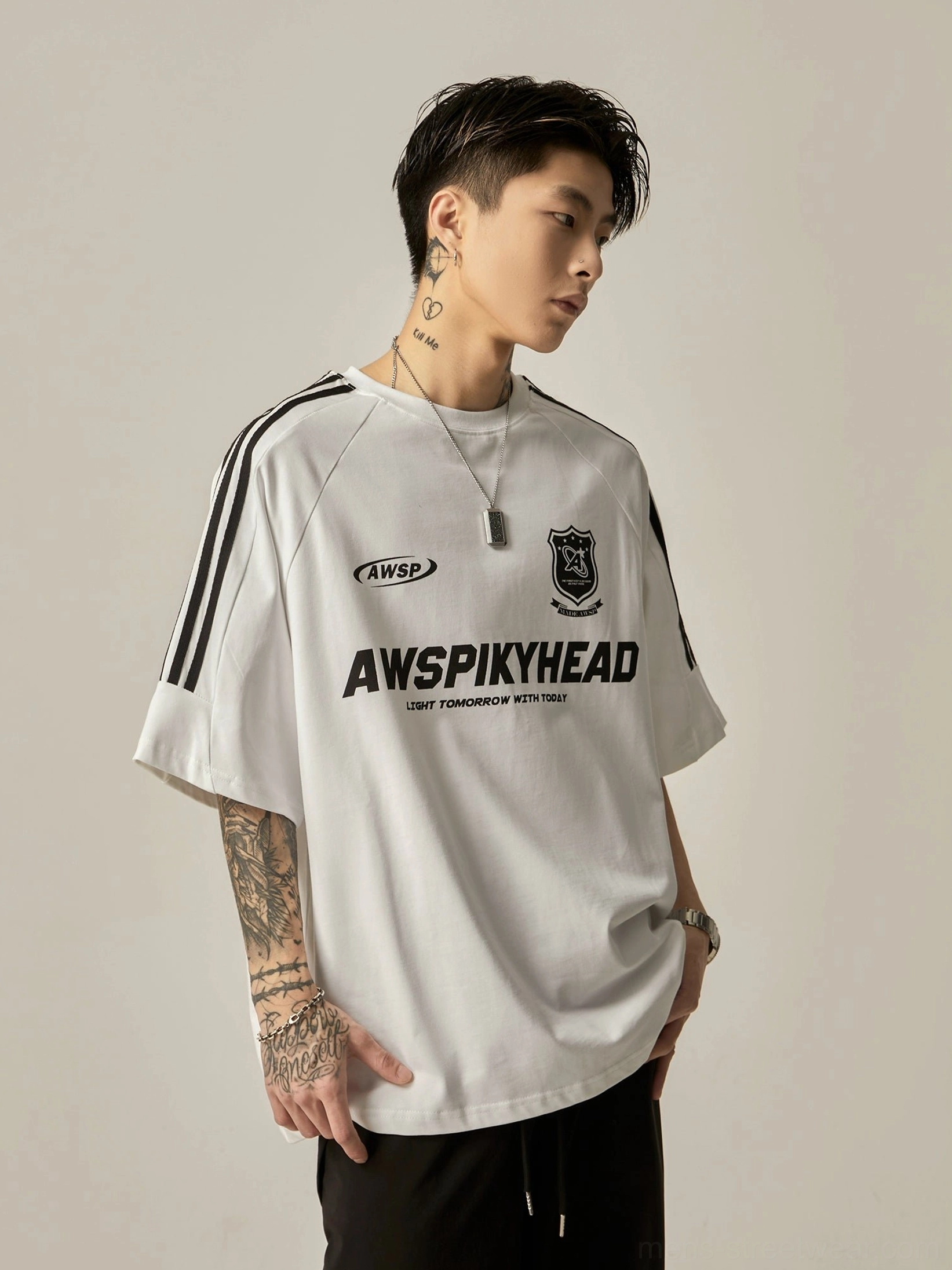 Oversized white football-themed raglan graphic tee side three-quarter view showing sleeve design with black stripe trims and chest brand lettering
