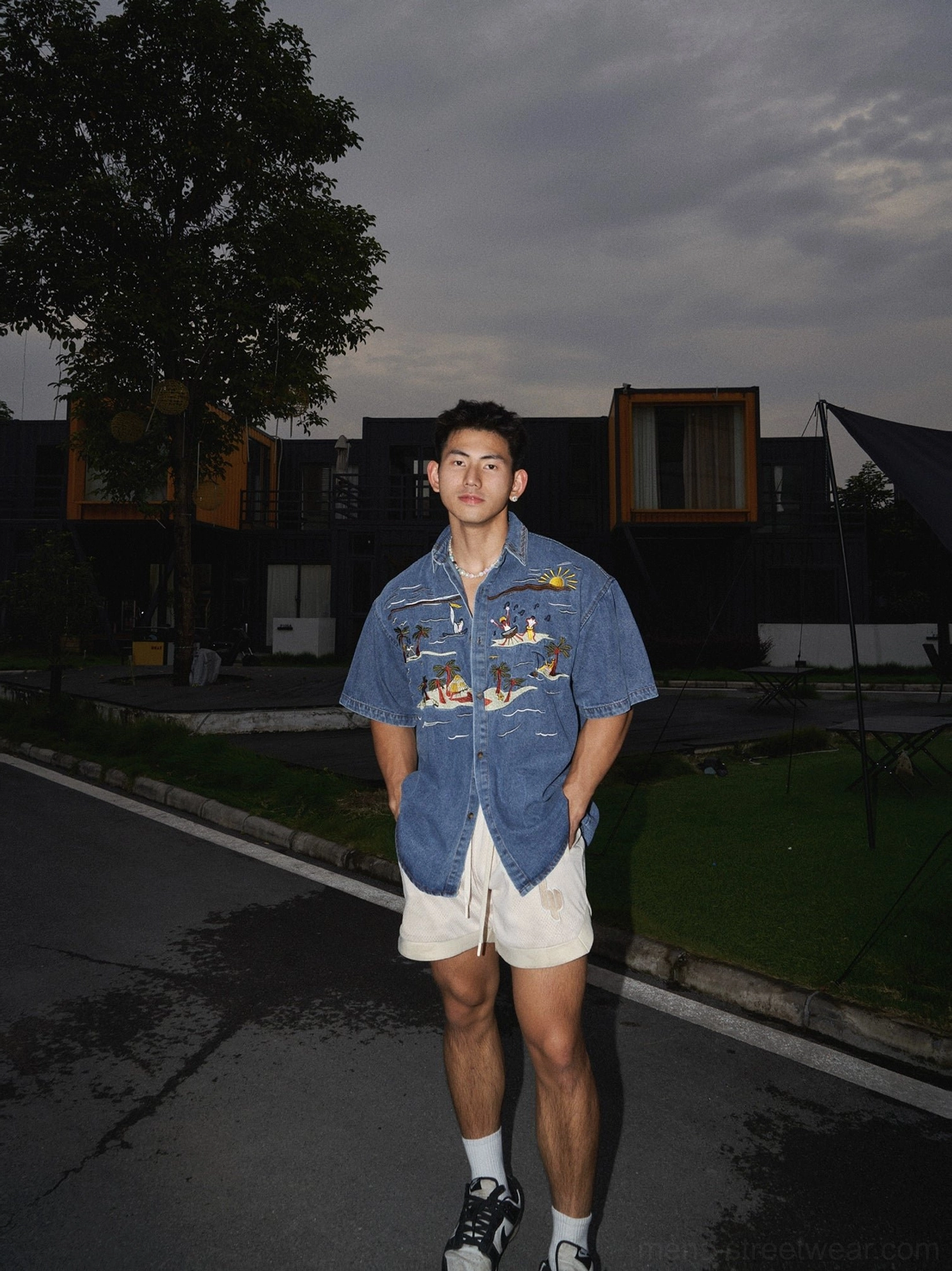 Relaxed oversized short sleeve denim shirt with coastal sunset embroidery styled with beige shorts and sneakers