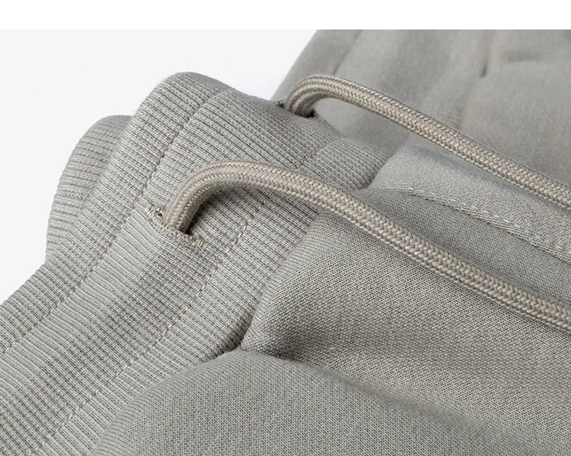 Top-down close-up waistband detail ribbed elastic waistband threaded drawstring taupe grey knit fabric seamless construction