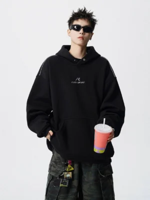 Black oversized sport hoodie with embroidered chest detail, dropped shoulders, kangaroo pocket, and relaxed Korean streetwear fit styled with camo cargo pants