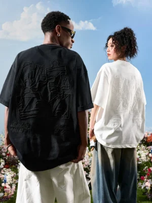Rear full view of two models wearing oversized embroidered puzzle graphic T-shirts in black and off white Korean streetwear style