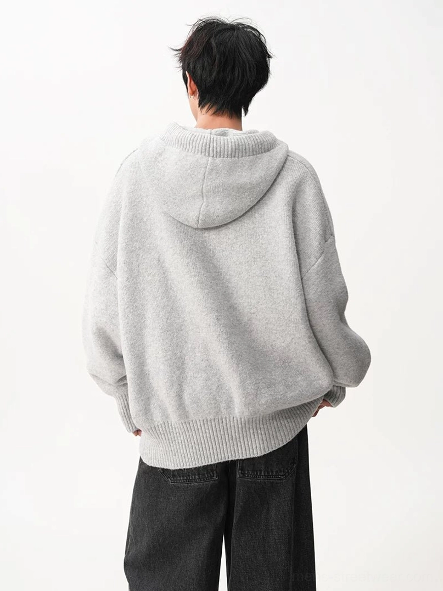 Back view of light gray brown oversized knit hoodie showing roomy hood dropped shoulders and ribbed hem