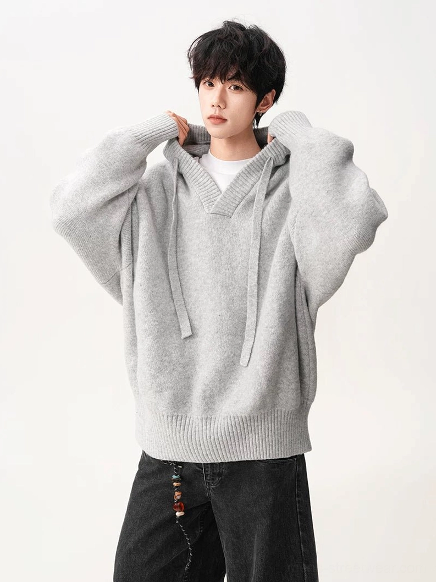 Close view of light gray brown V-neck knit hoodie showing adjustable drawstring hood and soft knit texture