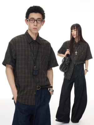 Male and female models wearing an oversized vintage brown plaid short sleeve streetwear shirt with dark wide leg denim