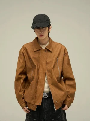 Dark brown oversized faux leather streetwear jacket styled with a beige tee and black jeans, featuring a soft suede-like texture, shirt collar, and elasticated hem
