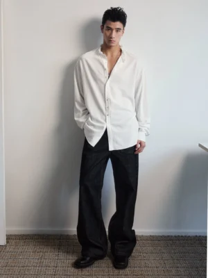 Full body view of a men's oversized white ruffle collar linen cotton streetwear shirt with dropped shoulders and long sleeves