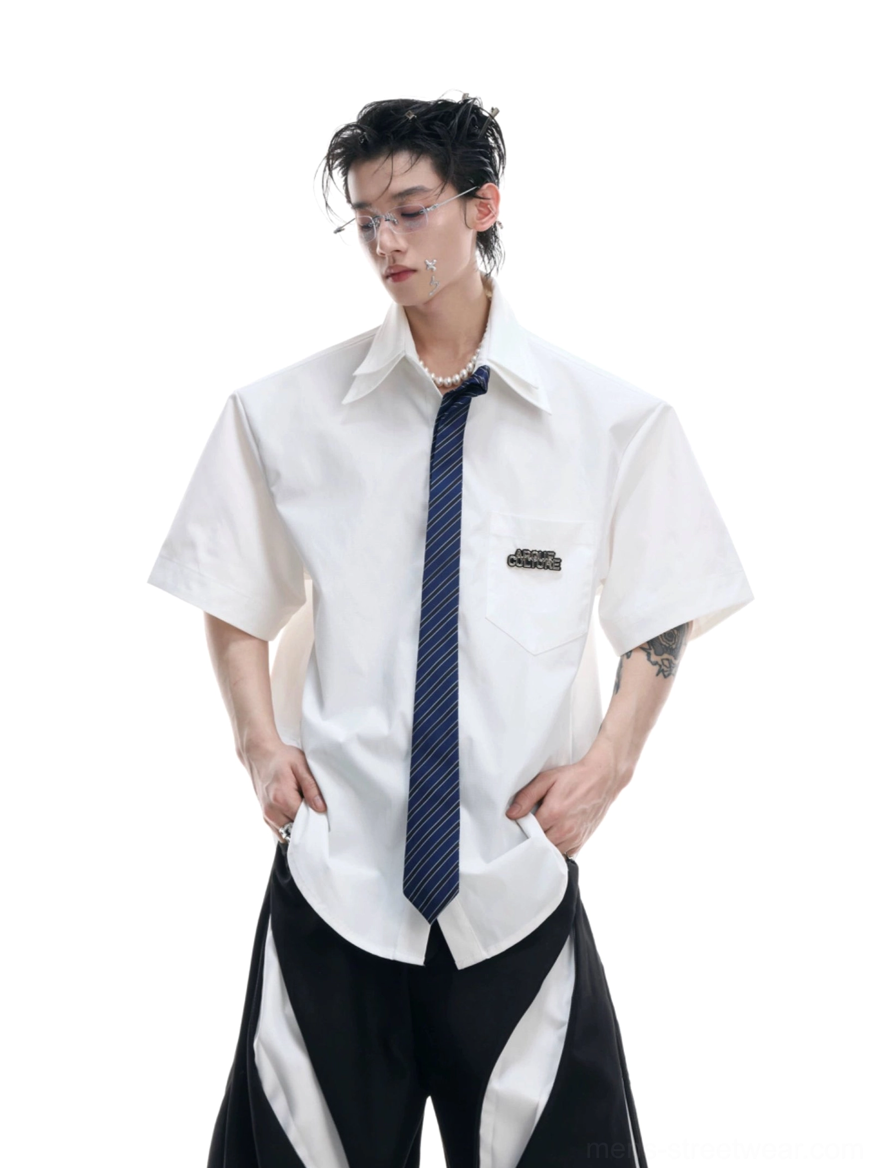 White oversized short sleeve shirt with dark blue necktie styled with black wide leg streetwear pants