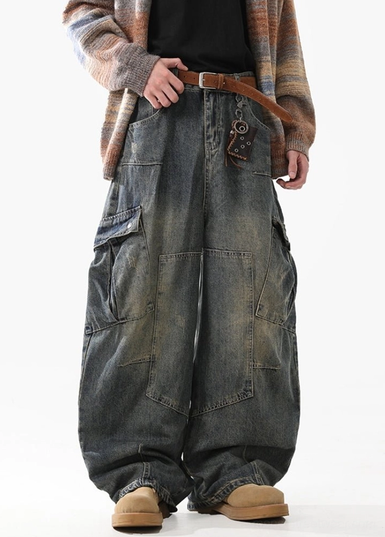 Front three-quarter view of oversized wide-leg cargo jeans with symmetrical side pockets, faded denim wash, and utility streetwear design