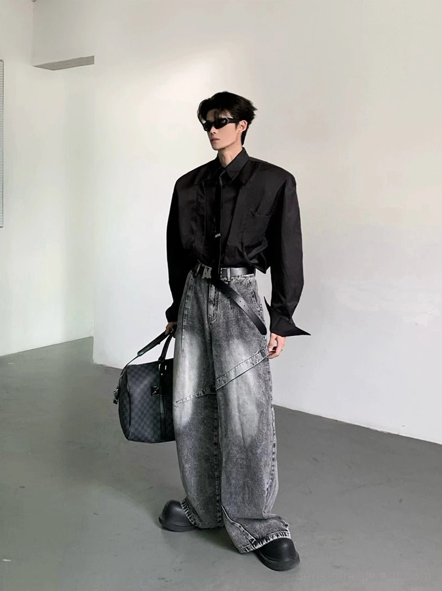 Side three-quarter view of black oversized wide-shoulder Korean streetwear dress shirt styled with belt gray denim and leather bag