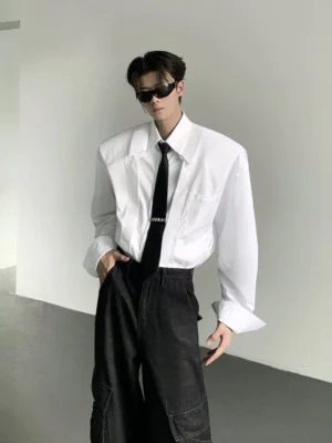 White oversized wide-shoulder Korean streetwear dress shirt with chest pocket styled with black necktie front three-quarter view