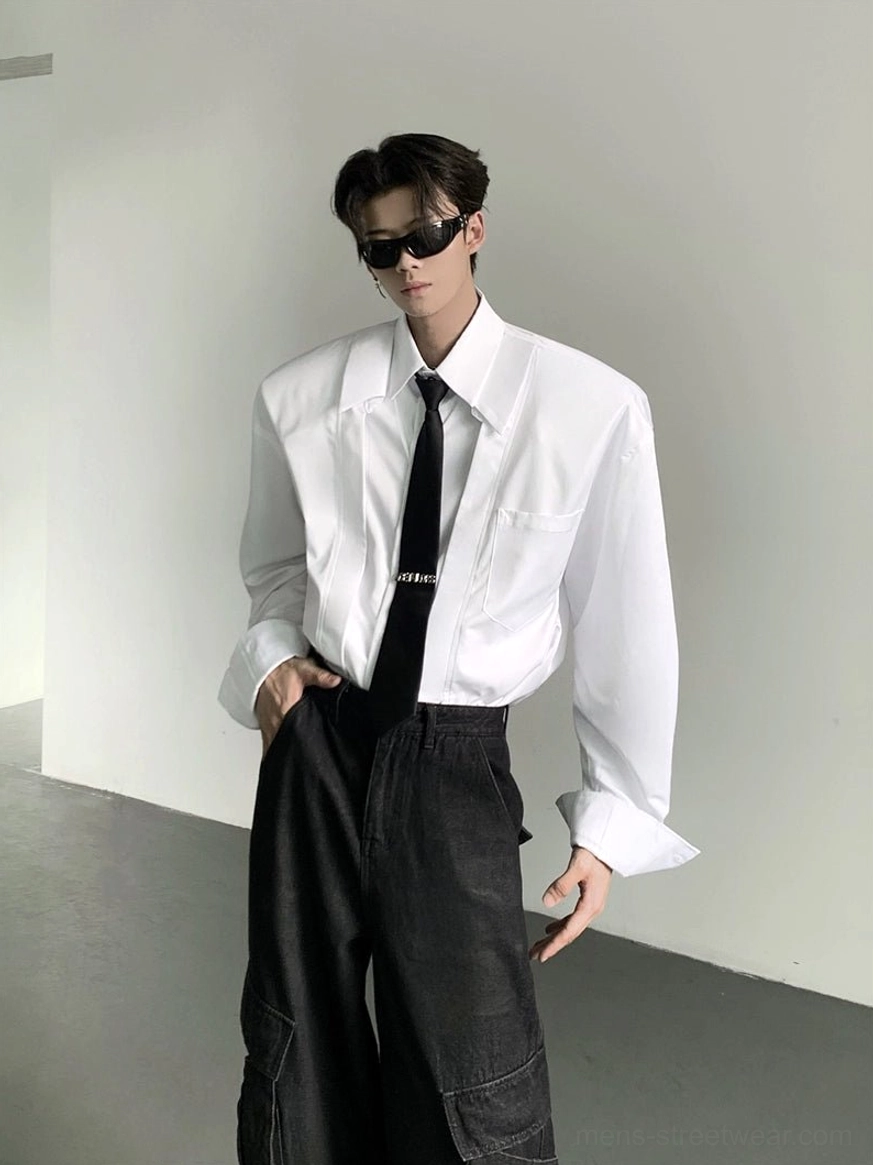White oversized wide-shoulder Korean streetwear dress shirt with chest pocket styled with black necktie front three-quarter view