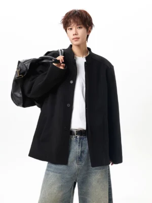 Black oversized wool-look stand collar jacket styled with a white t-shirt, blue jeans and shoulder bag