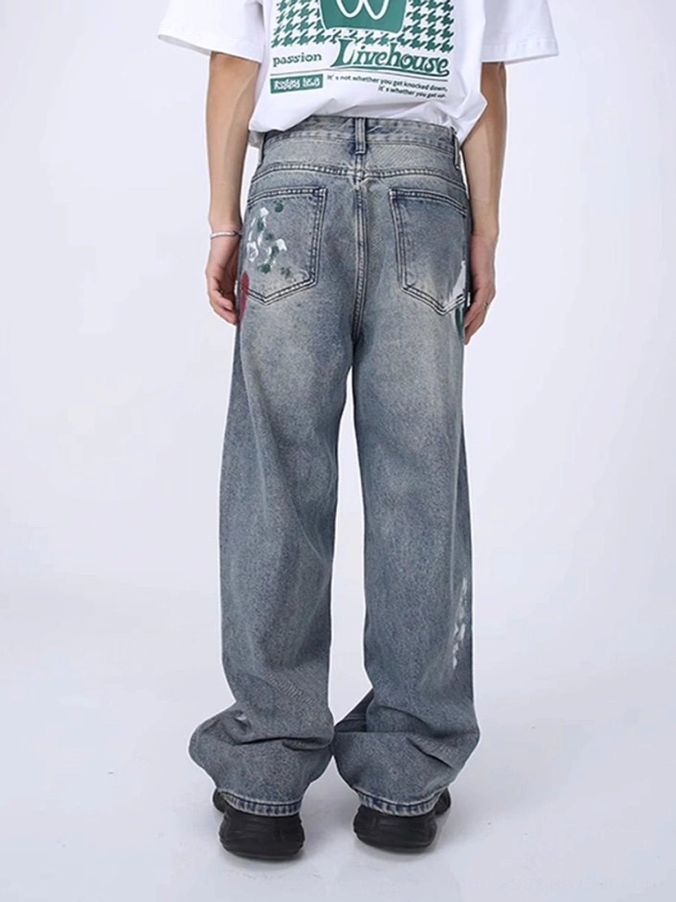 Rear view of faded light blue wide leg distressed streetwear jeans with classic back pockets, belt loops, and frayed hems