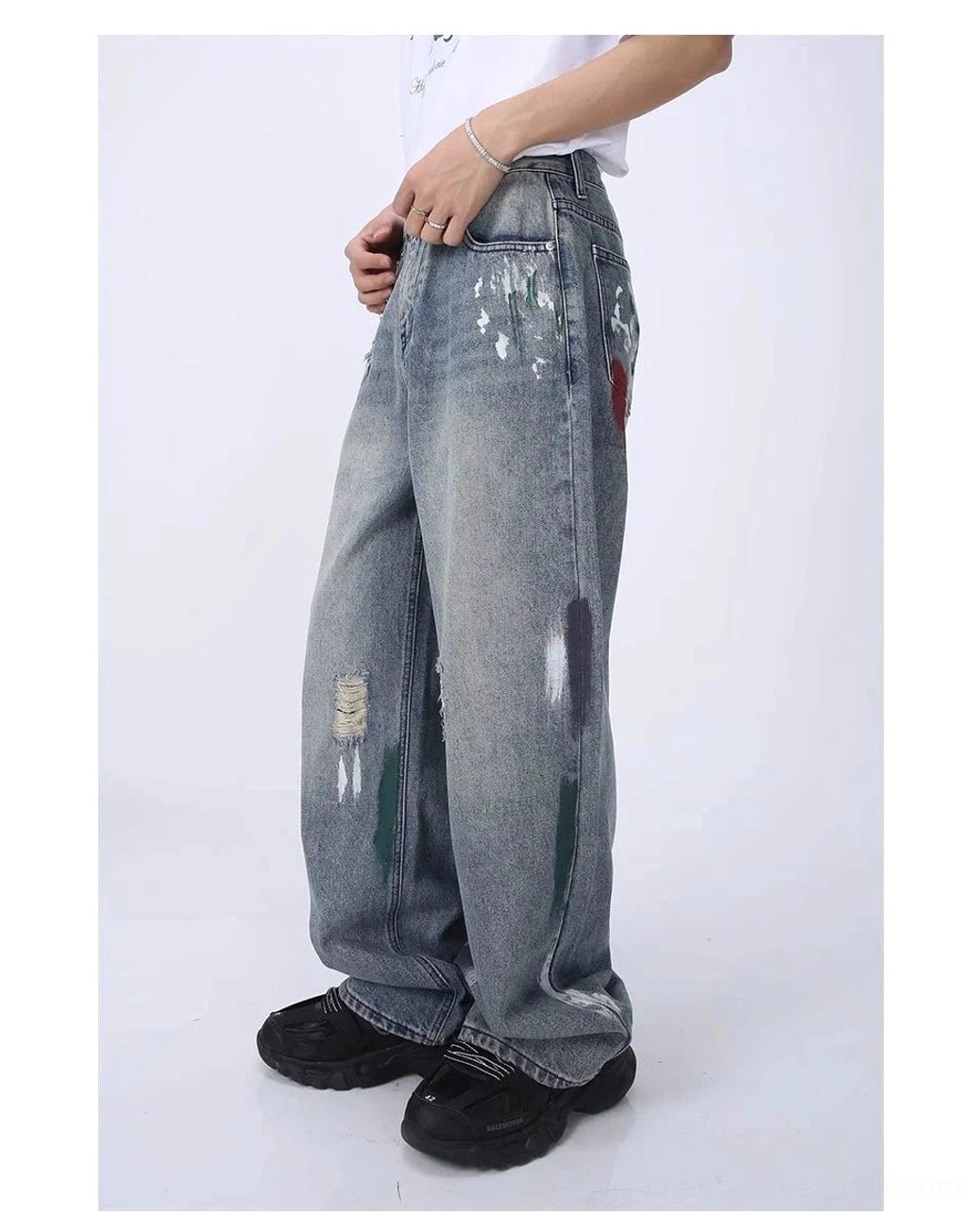 Right side view of distressed light blue wide leg streetwear jeans with red thigh paint splatter and frayed ripped details