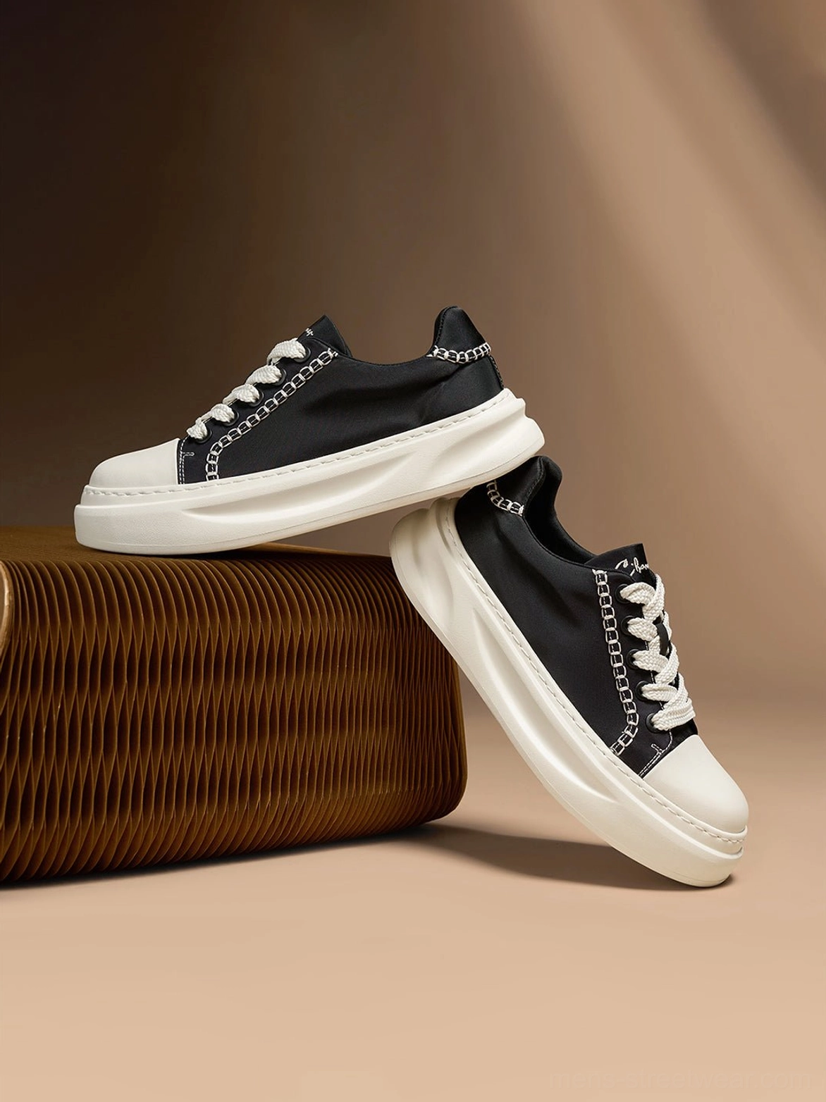 Pair of black chain-trim canvas platform sneakers stacked to display the thick rounded rubber sole and white contrast stitching
