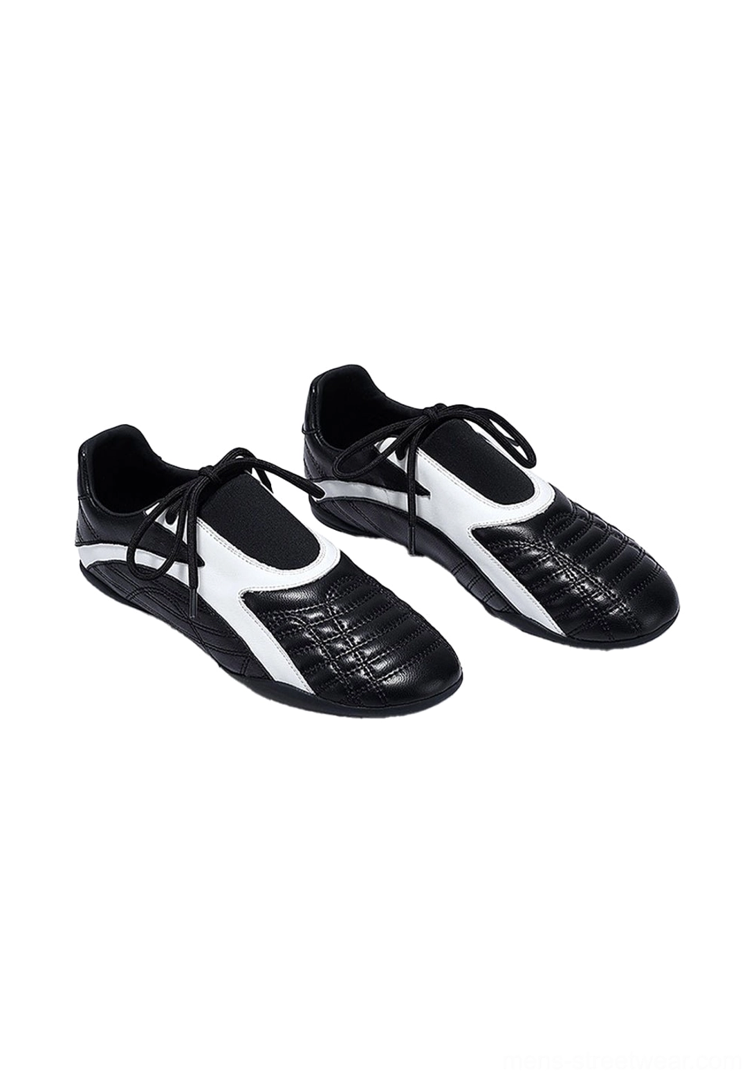 Pair of black quilted flat-sole sneakers displayed at an angle with white contrast side stripes, black laces, and a low-profile rubber outsole