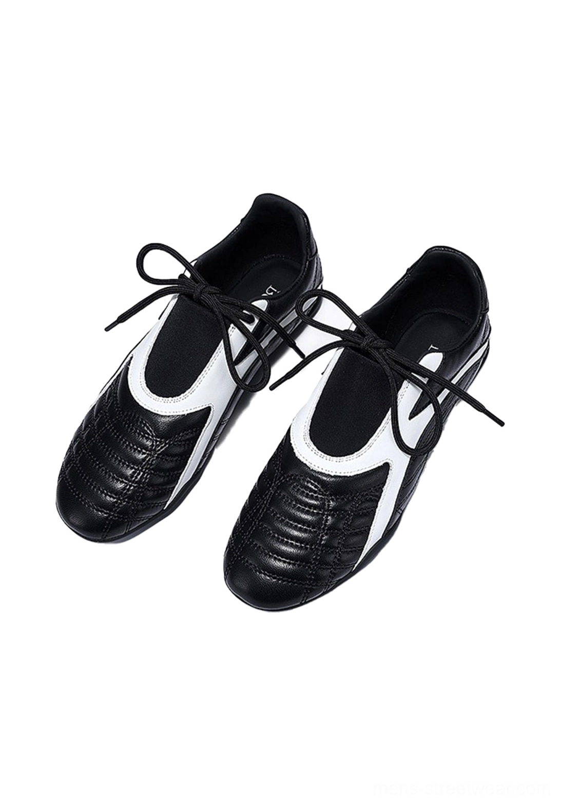 Pair of black and white lace-up flat sneakers shown from the front overhead angle with quilted toe caps and white upper panels