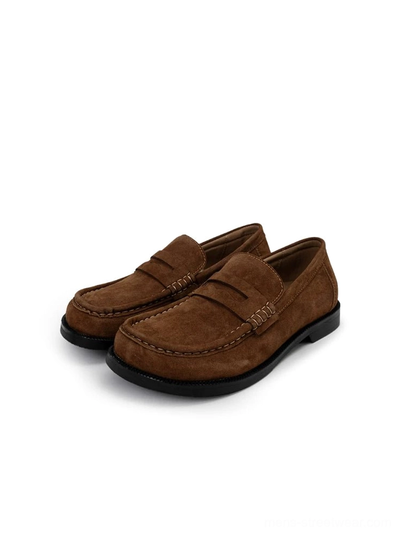 Pair of chestnut brown suede penny loafers on a white studio background, showing the matching finish, classic strap detail, and low-profile outsole