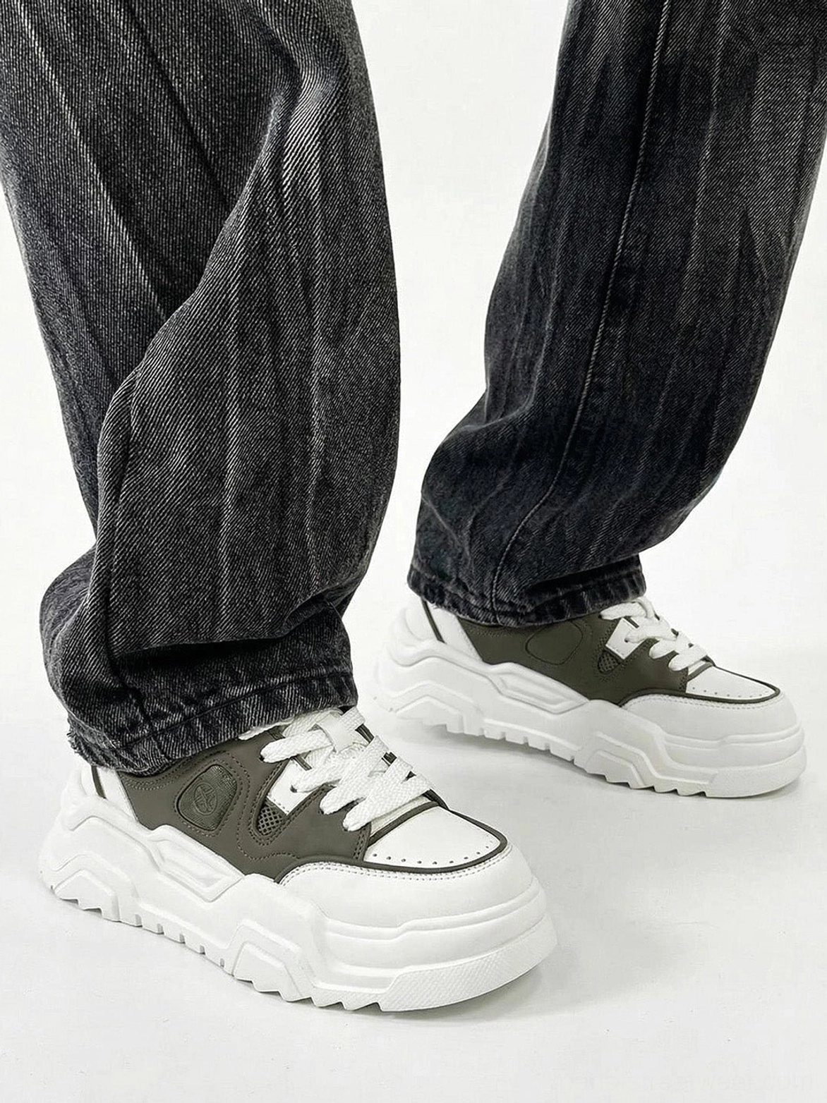 Paired monochromatic platform sneakers angled studio lighting showcasing shadow definition geometric cutout panel contrast