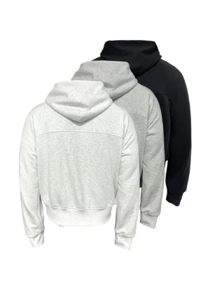Back three-quarter flat lay of black and heather gray panelled cropped zip-up hoodies with structured hoods