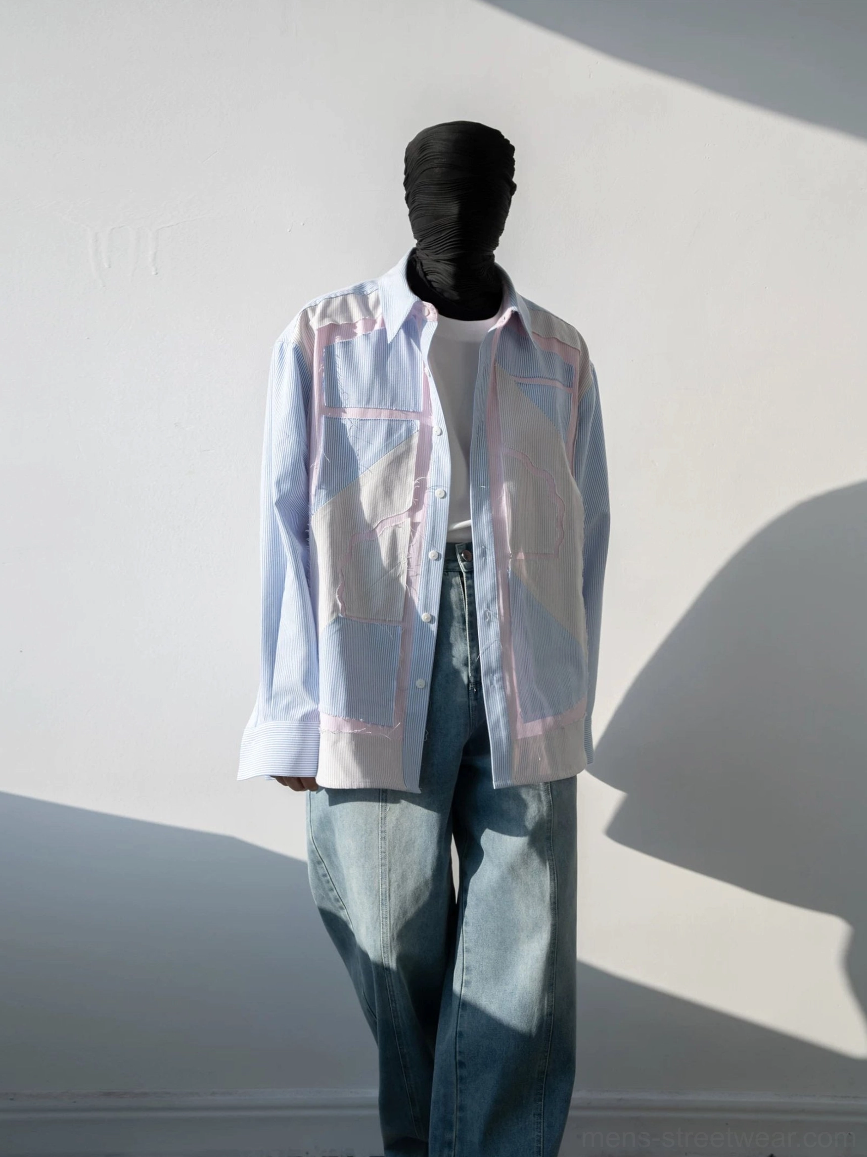 Pastel geometric patchwork pinstripe oversized shirt front view styled with wide-leg jeans in a sunlit studio