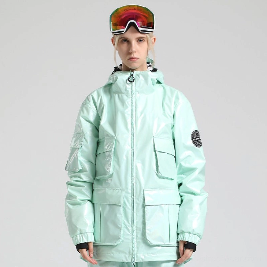 Pastel mint cyan glossy ski storm jacket with attached hood, front cargo pockets, embossed sleeve patch, and futuristic streetwear finish