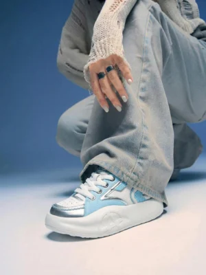 Pastel platform runner sneakers worn with loose denim pants and a knit sweater in a casual Korean streetwear outfit