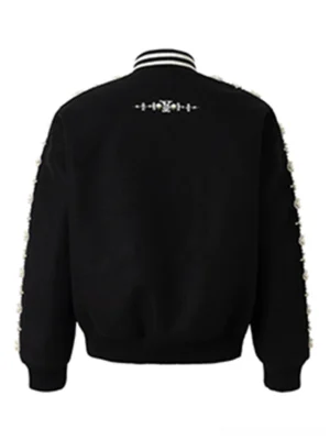 Back view of black pearl embellished varsity baseball jacket showing embroidered upper back detail and pearl trimmed sleeves
