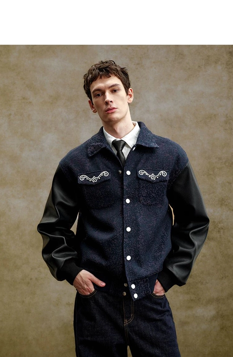 Full front studio view of a pearl embellished contrast sleeve varsity jacket with navy textured body, black faux leather sleeves, and ribbed trims