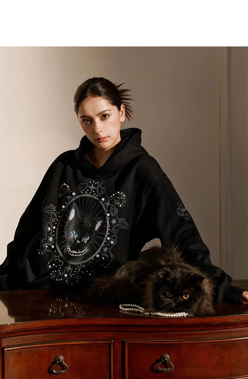 Black mystic cat oversized hoodie with pearl embellishments in a dark romantic vintage interior