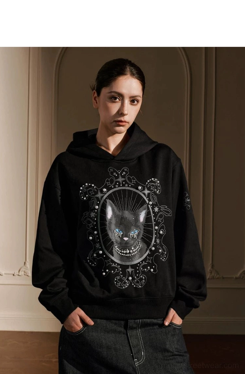 Female model wearing black pearl embellished mystic cat oversized gothic streetwear hoodie front view