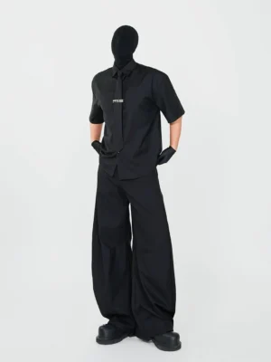 Full-body view of a black Korean streetwear shirt and wide-leg trousers outfit with matching tie, silver metal tie clip, black gloves, and chunky leather shoes