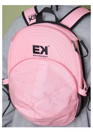 Pink canvas baseball cap backpack worn from a back three-quarter view showing the cap-inspired front panel and shoulder straps