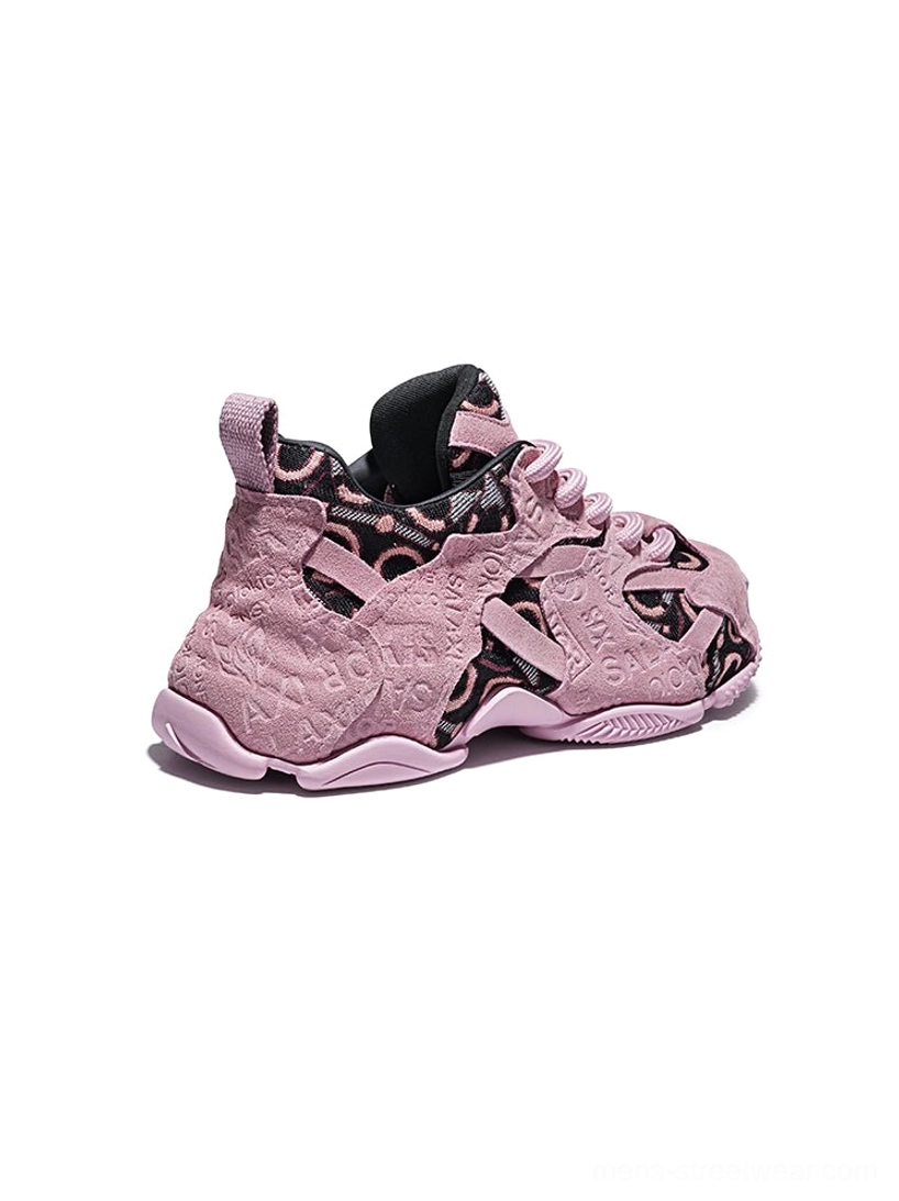 Rear side view of pink chunky dad sneakers showing the heel pull tabs, textured rubber outsole, suede overlays, and monogram-style side panels