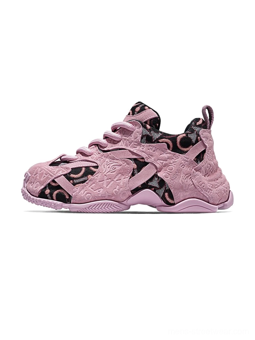 Pink embroidered chunky dad sneakers shown in a side front product view with dusty pink suede overlays, monogram-style jacquard panels, lace-up closure, and layered rubber outsole