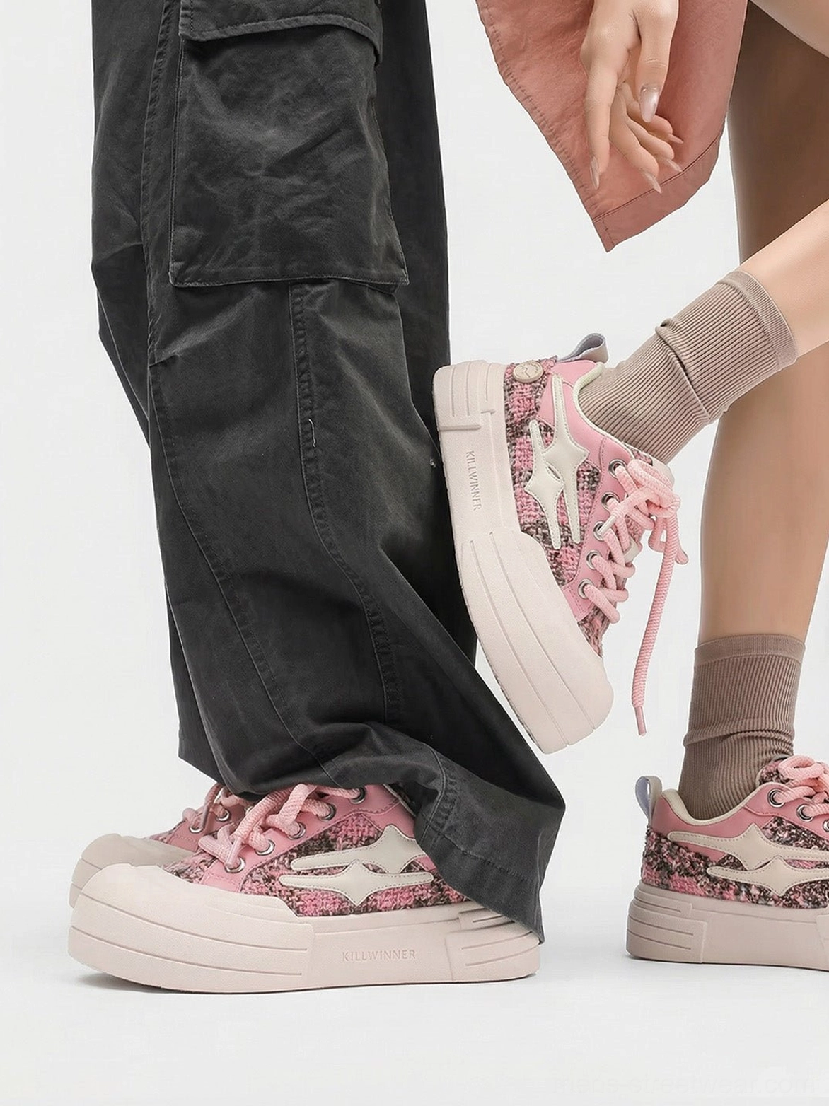 Pink star platform sneakers worn in a coordinated streetwear outfit with cargo pants and brown crew socks