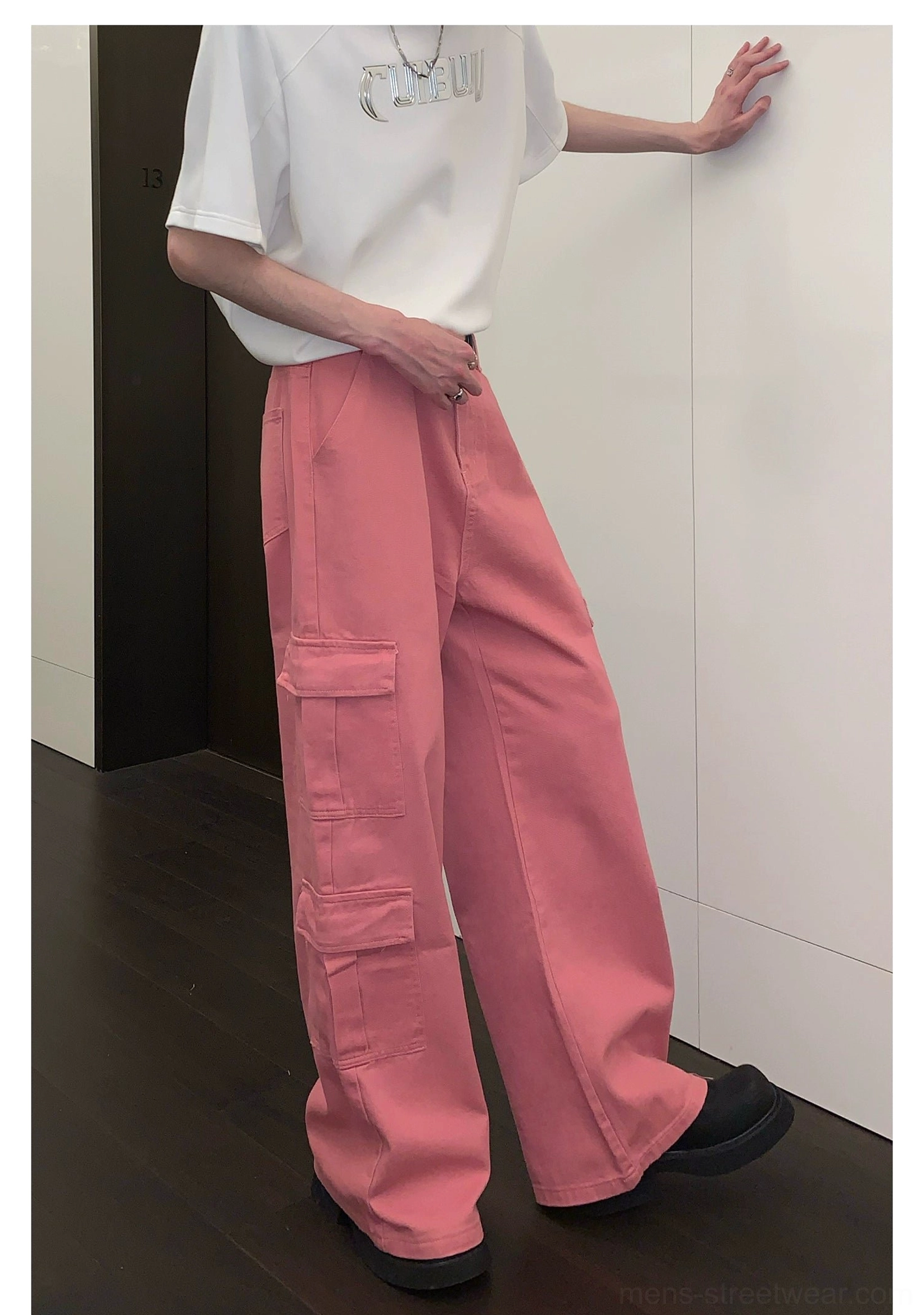 Pink wide-leg cargo pants product image featuring relaxed utility styling, flap pockets, and contemporary streetwear proportions