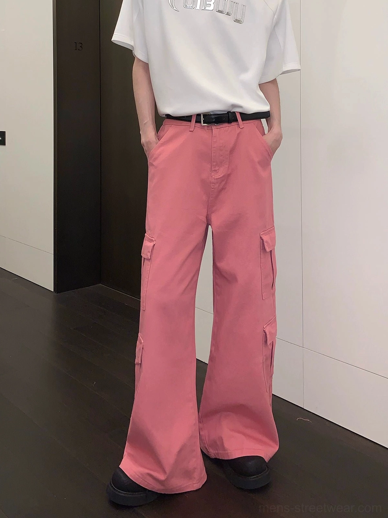 Pink wide-leg cargo pants shown from the front with hands in the waistband pockets and a relaxed Korean streetwear silhouette