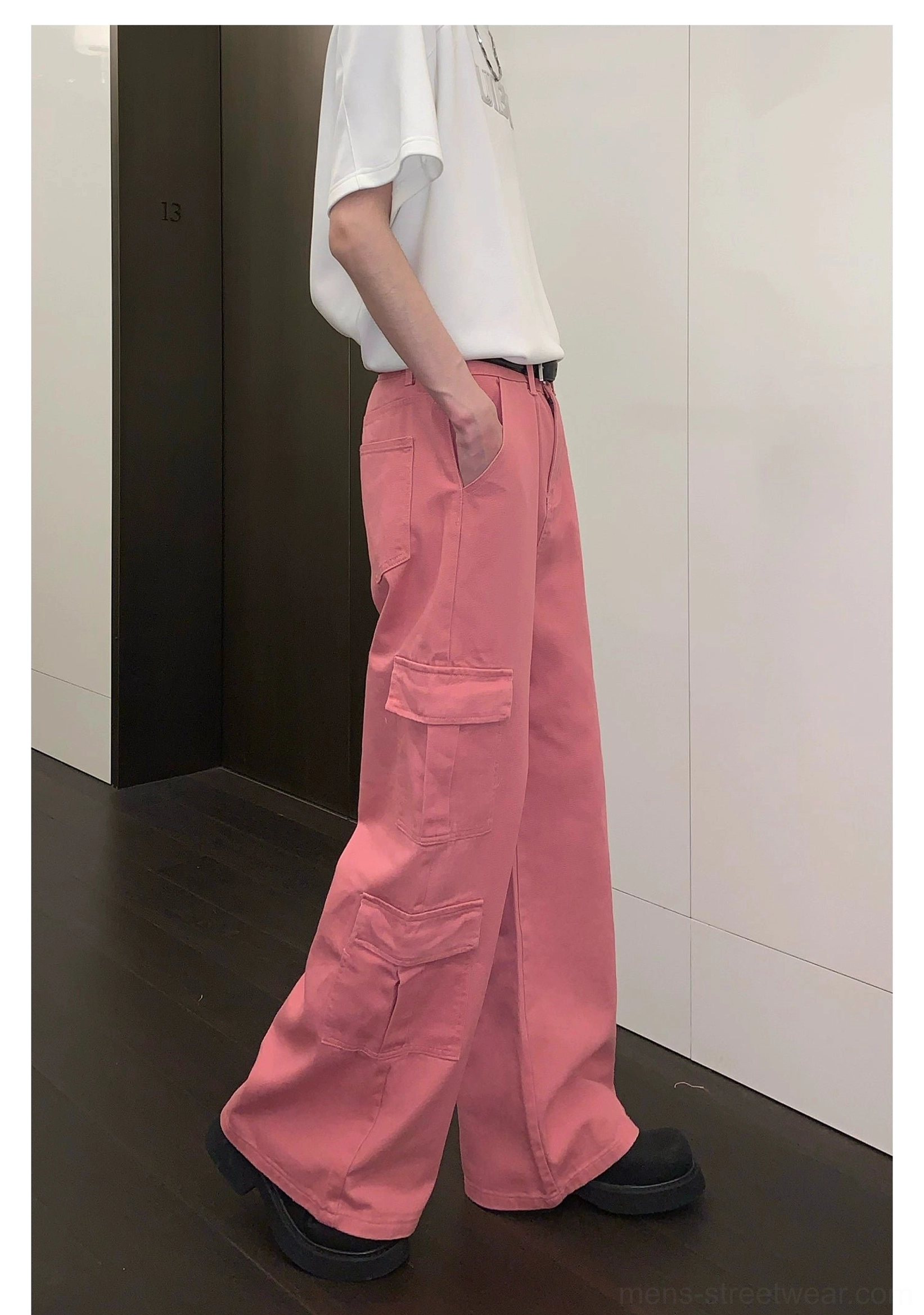 Right rear view of pink wide-leg cargo pants highlighting the right utility pocket and loose full-length streetwear cut